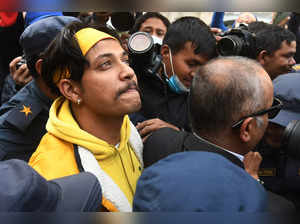 Nepali former national cricket captain Sandeep Lamichhane (L) is escorted by police outside the districtl court following his release on bail after three months in custody for rape charges, in Kathmandu on January 13, 2023.