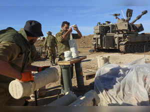Israeli soldiers prepare munitions near a self-propelled artillery howitzer in southern Israel near the border with the Gaza Strip on December 16, 2023, amid ongoing battles between Israel and the Palestinian militant group Hamas.