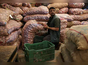 FILE PHOTO: A man sorts onions at a vegetable wholesale market in Mumbai