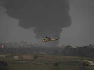 An Israeli military helicopter flies near the Israeli-Gaza border, as seen from ...
