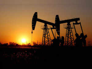 Pumpjacks are seen against the setting sun at the Daqing oil field in Heilongjiang