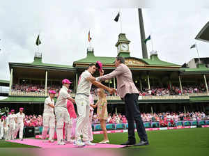 Australia’s captain Pat Cummins presents his pink cap to Glenn McGrath on Jane McGrath Day during day three of the Third cricket Test match between Australia and Pakistan at Sydney Cricket Ground on January 5, 2024 in Sydney.