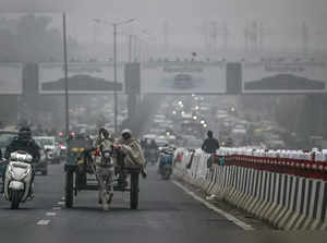 People ride a horse-driven cart on a cold foggy winter morning in New Delhi on January 5, 2024.
