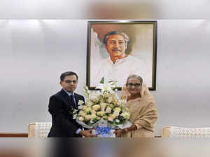 Indian High Commissioner to Bangladesh Pranay Verma (L) congratulates Bangladesh's Prime Minister Sheikh Hasina with a floral bouquet in Dhaka on January 8, 2024
