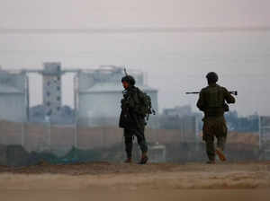 Israeli soldiers walk near the Israel-Gaza border