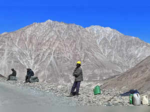 In this photograph taken on August 31, 2023, Border Roads Organization (BRO) labourers sit  along a hill road in Diskit on the outskirts of Nubra.