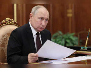 Russian President Vladimir Putin listens to Russian Railways CEO Oleg Belozerov ...