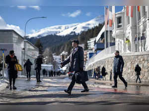 Participants walk in the street of the Alpine resort of Davos during the World Economic Forum (WEF) annual meeting in Davos on January 18, 2023.