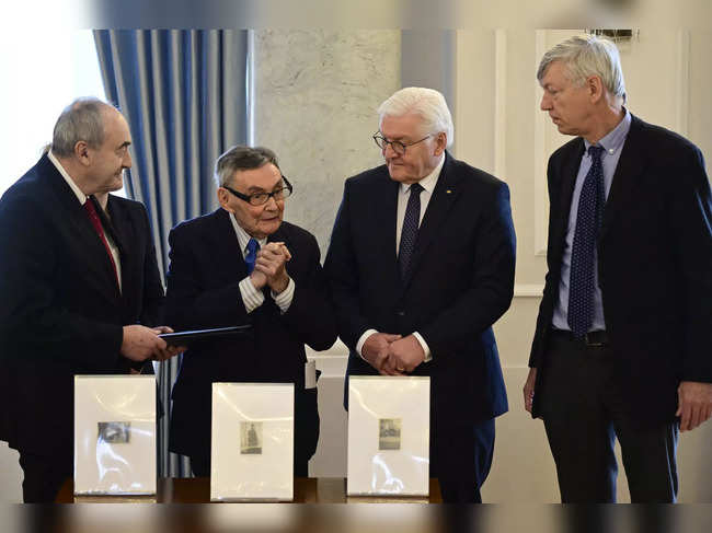 Polish historian Marian Turski (2nd L), President of the International Auschwitz Committee, thanks German President Frank-Walter Steinmeier (2nd R) as Hans-Reimer Rodewald (R) and Zygmunt Stepinski (L), Director of the Museum of the History of Polish Jews in Warsaw (POLIN Museum) look on during a ceremony to hand over photographs from the Warsaw Ghetto to the Museum of the History of Polish Jews in Warsaw on January 17, 2024 at the presidential Bellevue Palace in Berlin; the photographs were owned by Rodewald's mother Ingelene Rodewald.