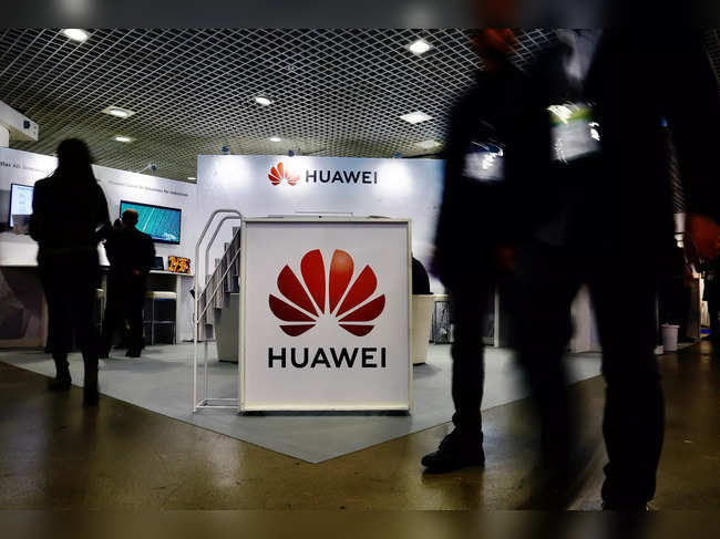 FILE PHOTO: Visitors walk past the Huawei logo at the World Artificial Intelligence Cannes Festival