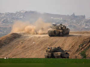 An Israeli tank fires towards Gaza, at the Israel-Gaza border