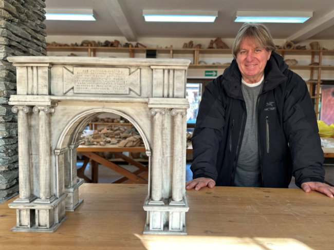 Miomir Korac, the leading archaeologist, poses next to a maquette of an ancient Roman triumphal arch, the remains of which were discovered at the site of Viminacium, a former Roman settlement near the town of Kostolac, Serbia.