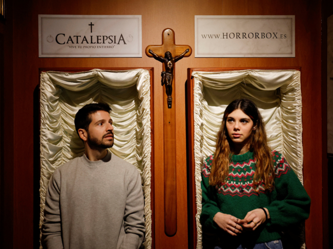 A couple of gamers, Miriam Castella and Carlos Granedo, participate in an extreme escape room named Catalepsia, which takes place inside two coffins simulating their funeral and trying to escape from them by working in pairs to solve puzzles and tricks, in Barcelona, Spain.