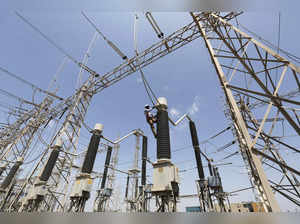 A technician repairs power supply lines at a power plant of Adani Power at Mundra Port in the western Indian state of Gujarat
