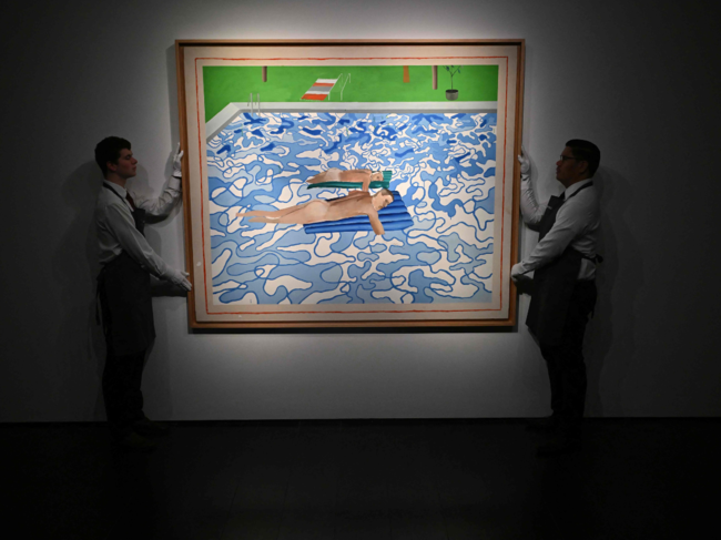 ?Gallery assistants pose with 'California' by British artist David Hockney during a photocal for the '20th/21st Century: London Evening Sale' at Christie's auction house in London?.