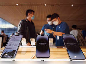 FILE PHOTO: A customer talks to sales assistants in an Apple store as Apple Inc's new iPhone 14 models go on sale in Beijing