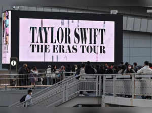 Fans look at a large video screen promoting the shows for US singer Taylor Swift outside the Tokyo Dome shortly before the start of the first leg of her Asia-Pacific "Eras Tour" in Tokyo on February 7, 2024.