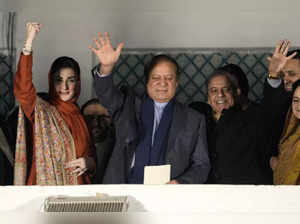 Former Prime Minister Nawaz Sharif, center waves with his brother Shehbaz Sharif...