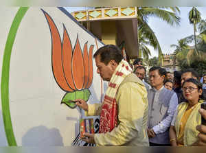 Guwahati: Union Minister and BJP leader Sarbananda Sonowal paints party's logo o...