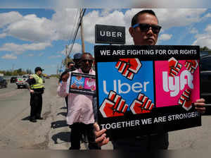 Uber and Lyft drivers protest during a day-long strike outside Uber’s office in Saugus