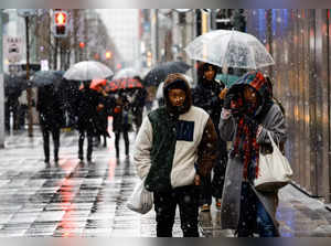 People walk on a street in the snowfall at Ginza shopping and amusement district in Tokyo