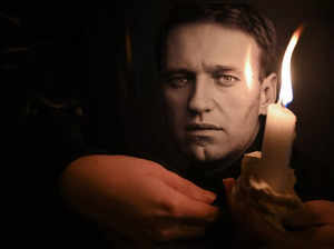 A man holds a candle and a photo of Russian opposition leader Alexei Navalny at a makeshift memorial as people demonstrate and pay their respect following his death in prison, in front of former Russian consulate in Frankfurt, western Germany on February 16, 2024.