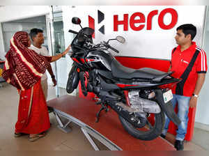 FILE PHOTO: Customers look at a Hero MotoCorp Karizma motorbike at Hero MotoCorp showroom in Ahmedabad