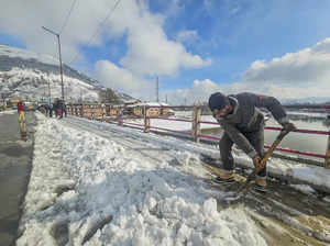 Baramulla: A worker clears snow from a road following fresh snowfall in Baramull...