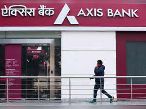 A man walks outside a branch of Axis Bank in New Delhi
