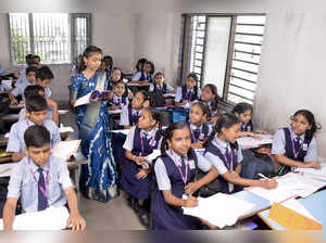 Surat, Sept 05 (ANI): A girl dressed up as a teacher teaches in a classroom on t...