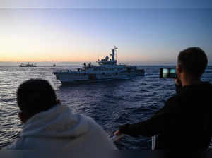 This photo taken on March 5, 2024 shows Philippine Coast Guard personnel filming a China Coast Guard vessel during a supply mission in the disputed South China Sea.