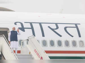 This handout photograph taken and released on February 13, 2024 by the Indian Press Information Bureau (PIB) shows the country's Prime Minister Narendra Modi gesture upon embarking an aircraft in New Delhi as he departs for a two-day visit to the United Arab Emirates (UAE).