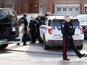 Ottawa Police Service officers surround a home after four children and two adults were found dead inside a neighbouring house in Ottawa