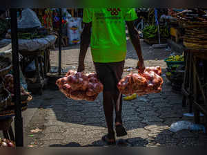 A man carries bags of onions in the Dantokpa market, one of the largest open-air market in West Africa, in Cotonou on February 29, 2024.