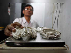 FILE PHOTO: A silver trader weighs his silver ornaments inside his shop in the western Indian city of Ahmedabad