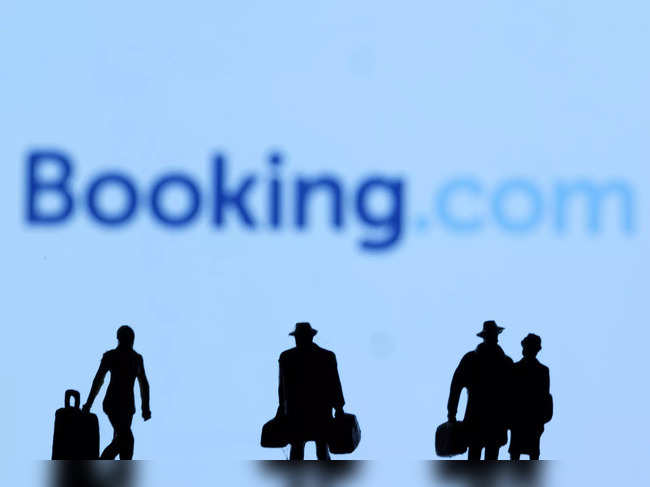 Figurines are seen in front of Booking.com logo