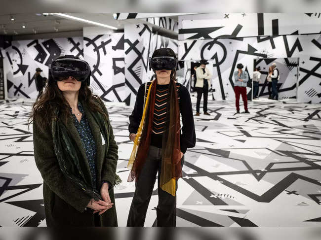 Visitors take part in a virtual reality experience as part of the exhibition 'Paris 1874 Inventing Impressionism' at the Musee d'Orsay in Paris on March 22, 2024, as 150 years ago, on April 15, 1874, the first impressionist exhibition opened in Paris.