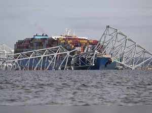 The steel frame of the Francis Scott Key Bridge sits on top of a container ship after the bridge collapsed collapsed in Baltimore, Maryland, on March 26, 2024.