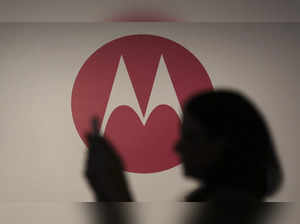 A woman takes a picture in front of a Motorola logo before the worldwide presentation of the Moto G mobile phone in Sao Paulo