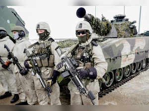 FILE PHOTO: Soldiers stand next to a military vehicle as Norwegian, Swedish and Finnish forces participate in a military exercise, in Kautokeino