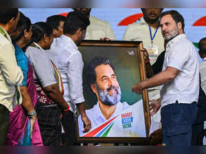 Indian National Congress party leader Rahul Gandhi (R) receives his photo frame during an election campaign meeting on the outskirts of Hyderabad on April 6, 2024, ahead of the country's general elections.