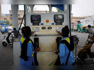 FILE PHOTO: Workers pump fuel at a petrol station in Ahmedabad