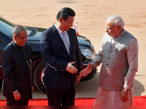 FILE PHOTO: India's PM Modi and China's President Xi shake their hands as India's President Mukherjee looks on at the forecourt of the Rashtrapati Bhavan presidential palace in New Delhi