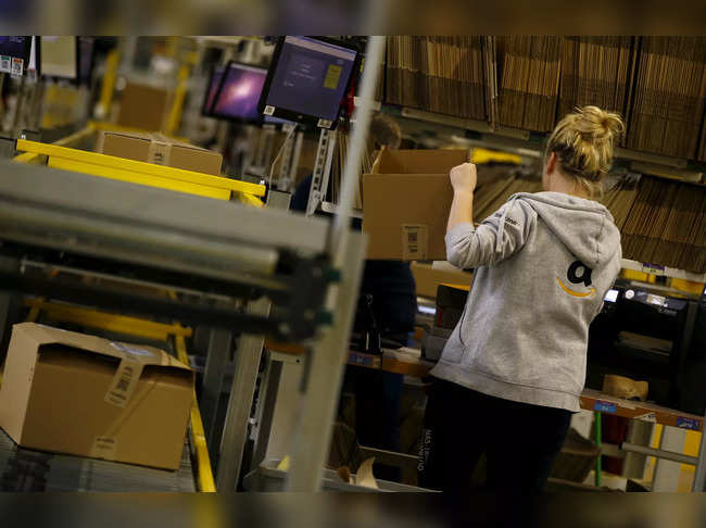 FILE PHOTO: Worker packs products at an Amazon Fulfilment Center in Wroclaw