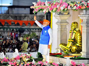 Mangaluru: Prime Minister Narendra Modi waves at supporters before a road show a...