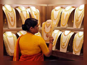 FILE PHOTO: A saleswoman picks gold necklaces to show it to a customer inside a jewellery showroom on the occasion of Akshaya Tritiya, a major gold buying festival, in Kochi