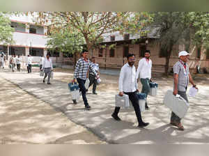 Election staff carry Voter Verifiable Paper Audit Trails (VVPAT) and Electronic Voting Machines (EVM) to a polling station, ahead of the first phase of the election, in Bikaner