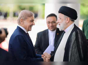 Pakistan's Prime Minister Shehbaz Sharif greets Iranian President Ebrahim Raisi on his three-day official visit in Islamabad
