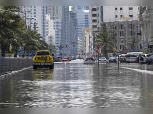 A car drives down a flooded street in Sharjah on April 20, 2024.