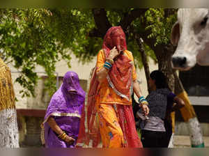Women walk towards a polling station to cast their ballot in the first phase of voting for the India's general elections in Parbatsar in Rajasthan, on April 19, 2024.